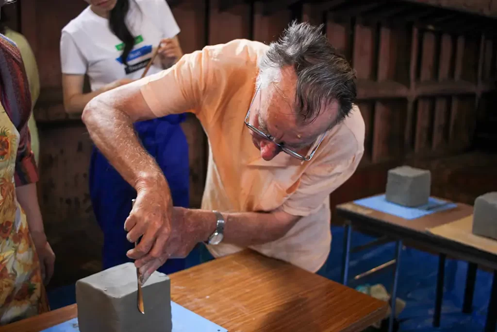 クロードさんが粘土をナイフで整えている。