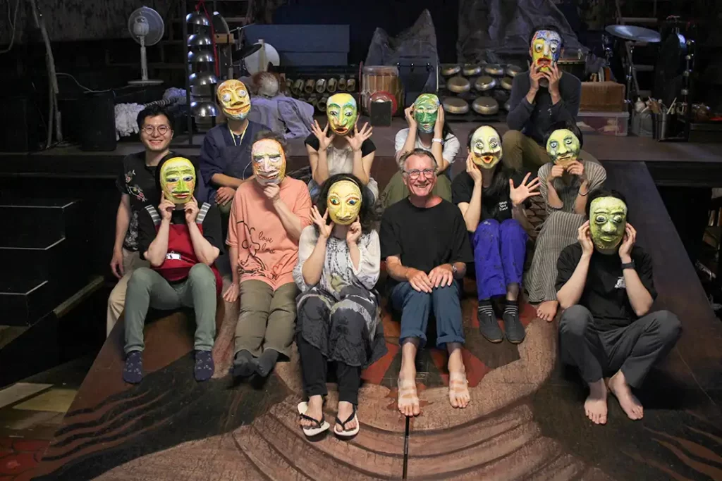 仮面の完成後、クロードさんと参加者の集合写真。参加者は完成したばかりの仮面を顔にかぶっている。